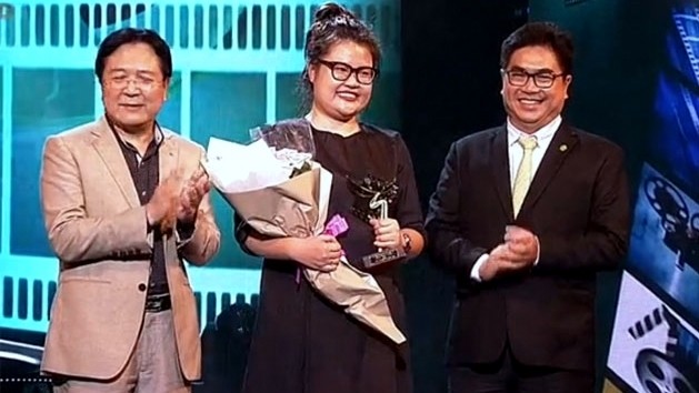 Director Kay Nguyen (C) receives the Best Feature Film at the Golden Kite Awards presented to The Tailor.