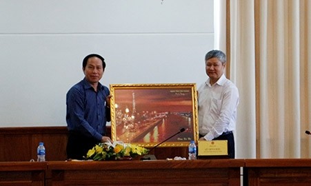 Chairman of the Hau Giang provincial People’s Committee Le Tien Chau (L) presents a souvenir to a representative from the delegation of businesses.