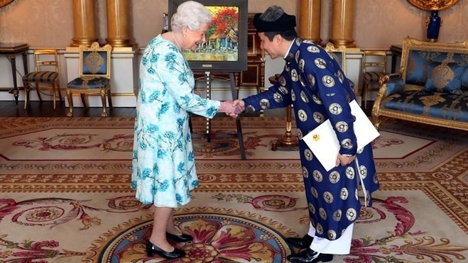 Vietnamese Ambassador to the UK (R) shakes hands with Queen Elizabeth II while presenting credentials. (Photo: VNA)