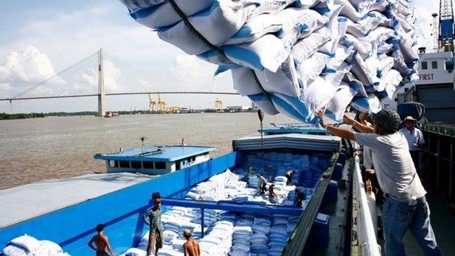 Rice bags are loaded onto a barge for shipment (Photo: VNA)