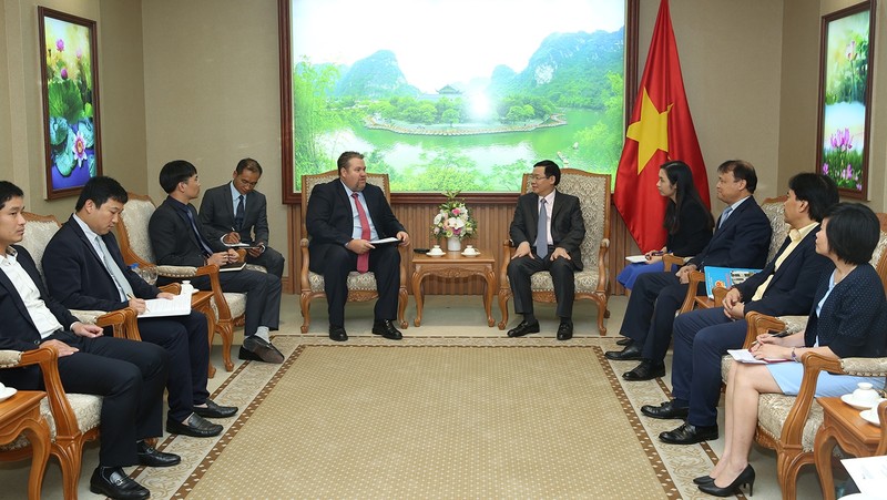 Deputy Prime Minister Vuong Dinh Hue (R) receives President of AES Vietnam David Stone
