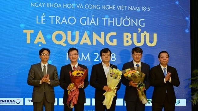 Deputy PM Vu Duc Dam (far left) and Minister of Science and Technology Chu Ngoc Anh (far right) applaud the three scientists who are winners of this year’s Ta Quang Buu Award. (Photo: NDO)