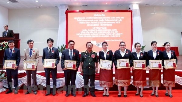 Lao Minister of National Defence, Senior Lieutenant General Chansamone Chanyalath (fifth from left), presents the Bravery Orders to outstanding staff members of Unitel (Photo: VNA)