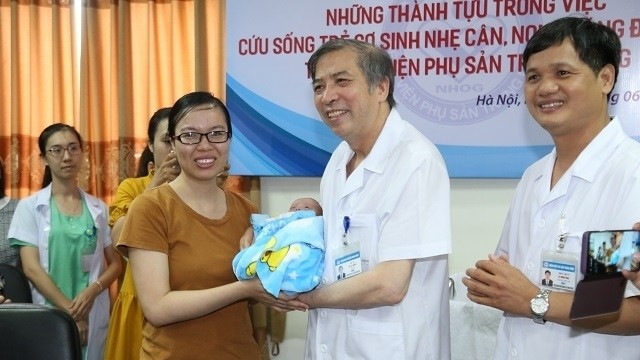 Director of the National Hospital of Obstetrics and Gynecology Vu Ba Quyen (C) congratulates the baby on hospital discharge on June 7. (Photo: NDO)