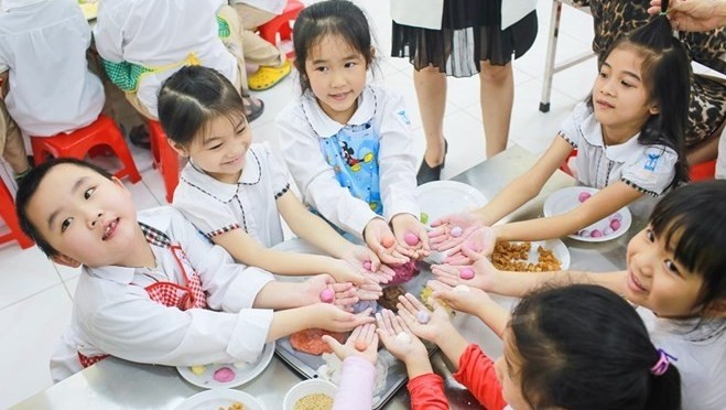 Children trying their hands at making cakes at a cooking class (Photo: VN+)