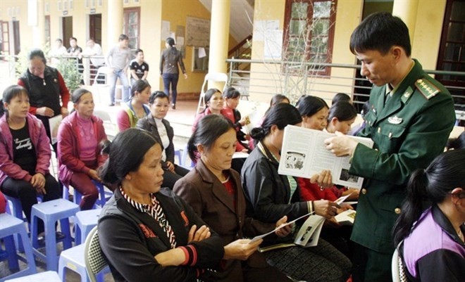 An official from the Na Hinh Border Guard Station delivers leaflets about heroin prevention and control to residents in Thanh Long commune, Van Lang distrrict, the northern mountainous province of Lang Son (Photo: VNA)
