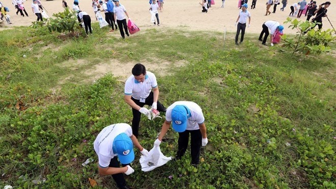 Participants in the “Joining hands to protect the ocean” programme clean up a beach in Da Nang city (Photo: VNA)