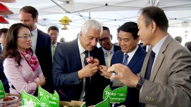 Chairman of Hanoi municipal People's Committee, Nguyen Duc Chung and Vietnamese Ambassador to France Nguyen Thiep introduce Vietnamese farm produce to CEO of Rungis International Market, Stéphane Layani