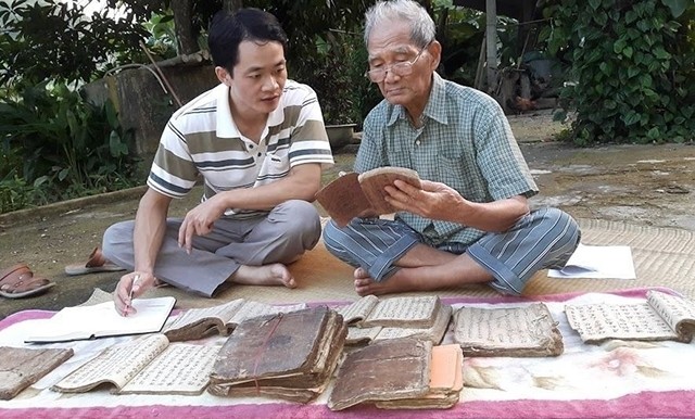 Writer Nong Viet Toai (R) is among few men who can read and thoroughly grasp the contents of ancient documents in Bac Kan province 