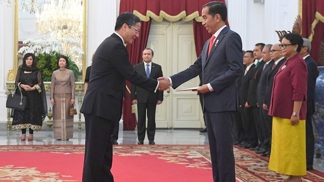 Vietnamese Ambassador to Indonesia Pham Vinh Quang (L) presents a letter of credence to Indonesian President Joko Widodo (Photo: VNA)