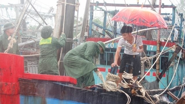 Soldiers are helping a fisherman to securely anchor his ship. (Image: Thanh Chau)