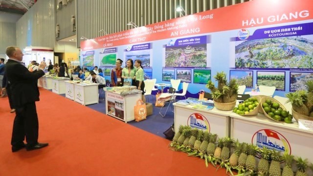 A visitor taking a photo in front of a booth showcasing products from the Mekong River delta at ITE HCMC 2017 (Photo: zing.vn)