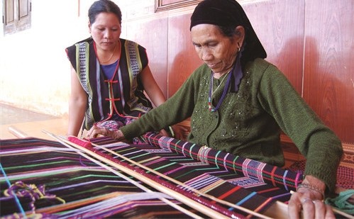  A M’nong ethnic elder weaving brocade in a traditional loom (Photo: dantocmiennui.vn)