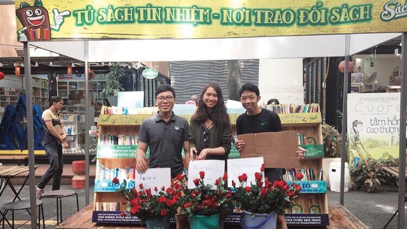 Huynh Quang Dung (first from left) and his teammates standing in front of Sach Chuyen Tay's stall on Nguyen Van Binh Book Street, Ho Chi Minh City (Photo: Sach Chuyen Tay)