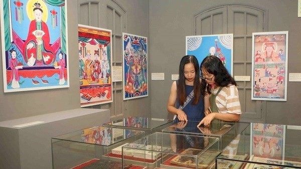 Visitors exploring the Vietnamese folk paintings at an exhibition which opened on August 29 at the Imperial Citadel of Thang Long in Hanoi (Photo: VNA)