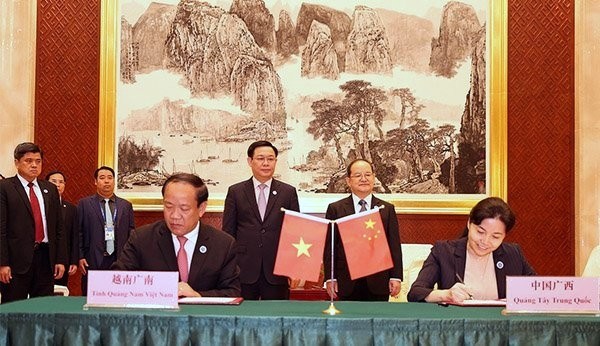 Deputy PM Vuong Dinh Hue (L) and Chinese Party Secretary of Guangxi Zhuang Autonomous Region Lu Xinshe witness the signing of an MoU on establishing friendly cooperation relations between Vietnam’s Quang Nam province and China’s Guangxi Zhuang Autonomous Region. (Photo: VGP)