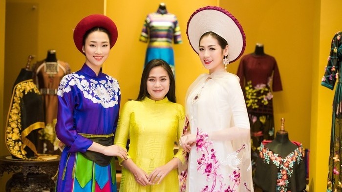 Designer Lan Huong (C) and two models wearing her Ao Dai creations