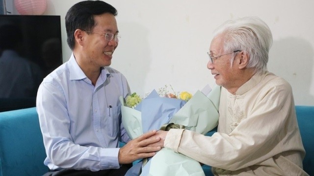 Politburo member Vo Van Thuong (L) salutes People’s Artist Tran Bang (Photo: tuyengiao.vn)