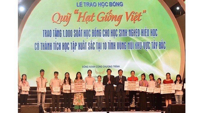 Editor-in-Chief of Nhan Dan Newspaper, Thuan Huu (seventh from right) and Secretary of Dien Bien provincial Party Committee, Tran Van Son, present Vietnamese Seeds Fund scholarships to local disadvantaged students at the event. (Photo: NDO)