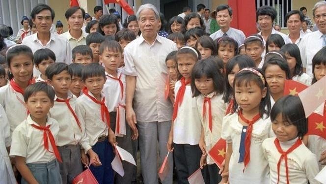 Former Party General Secretary Do Muoi surrounded by teachers and students of An Thach School in Ben Luc district, Long An province (Photo: VNA)