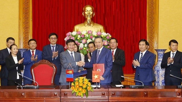 Vietnamese Minister of Public Security To Lam (R) and Mongolian Minister of Justice and Home Affairs Tsend Nyamdorj exchange the signed agreement on the transfer of sentenced persons after their talks in Hanoi on October 16. (Photo: VNA)