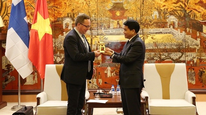 Chairman of the Hanoi People’s Committee Nguyen Duc Chung (right) presents a souvenir to Finish Minister of Economic Affairs Mika Lintila. (Photo: hanoimoi)