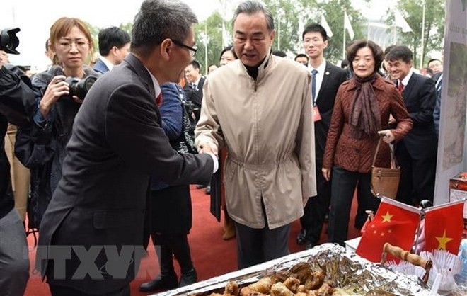 Chinese State Councillor and Foreign Minister Wang Yi visiting Vietnamese pavilion at the bazaar (Photo: VNA)
