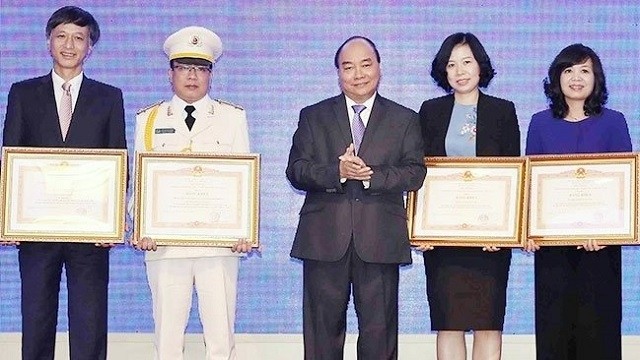 PM Nguyen Xuan Phuc (C) presents the Certificate of Merit to the outstanding collective with contribution to the successful organisation of the World Economic Forum on ASEAN 2018 in Vietnam last month. (Photo: VNA)