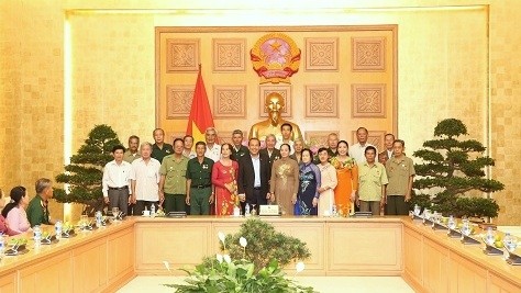 Deputy PM Truong Hoa Binh (C, in black suit) joins delegates who are revolutionary contributors from Ca Mau province in a group photo at a reception for the delegation in Hanoi on October 25. (Photo: VGP)