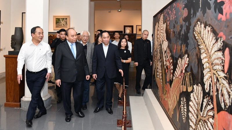 PM Nguyen Xuan Phuc appreciates a lacquer painting by Nguyen Gia Tri.