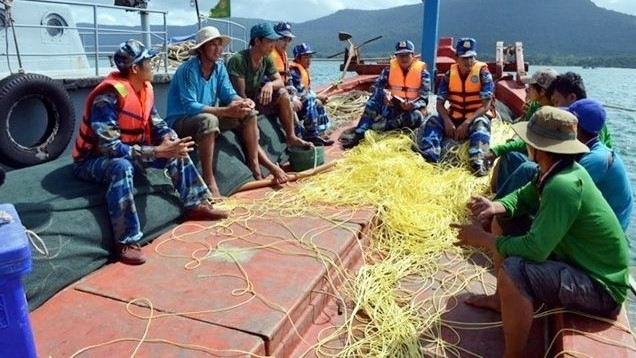 Kien Giang Border Guards provide information on the regulations related to fishing activities for local fishermen. (Photo: Le Sen)