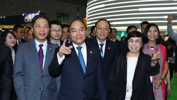 Prime Minister Nguyen Xuan Phuc (second from left) visits Vietnam's national stall at China International Import Expo 2018 (Source: VNA)
