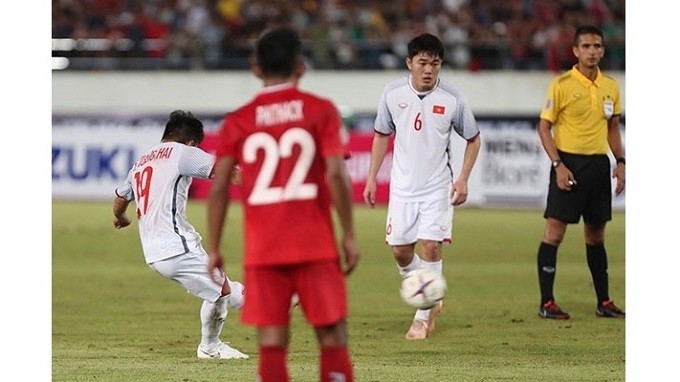 Vietnamese forward Nguyen Quang Hai (no. 19) impresses with a curling freekick toward the bottom corner of the Lao goal in their Group A opener at the 2018 AFF Suzuki Cup on November 8.