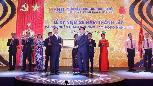 Deputy Prime Minister Vuong Dinh Hue (R) presents the second-class Labour Order to SHB on the occasion of the bank’s 25th anniversary, Hanoi, November 13, 2018. (Photo: NDO/Hong Anh)