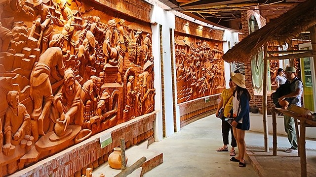 A bas-relief depicting the history of Thanh Ha pottery village at the Thanh Ha terra-cotta park