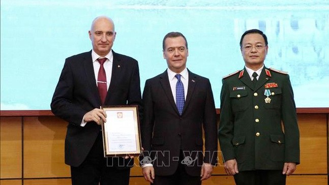 Russian Prime Minister Dmitry Medvedev presents the Certificate of Honour to the Vietnam-Russia Tropical Centre's staff. (Photo: VNA)