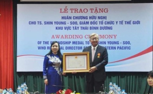 Minister of Health Nguyen Thi Kim Tien (left) presents the Friendship Order to Dr. Shin Young-soo, WHO Regional Director for the Western Pacific.  