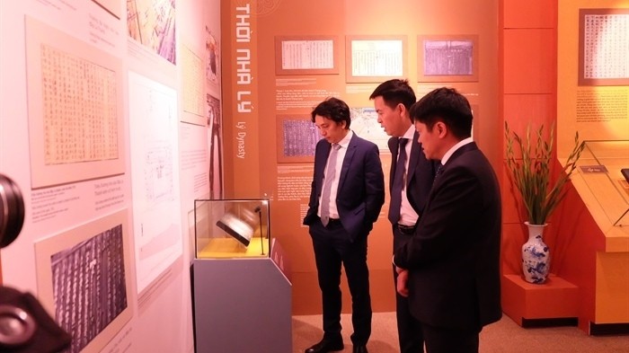 Visitors look at a woodblock on show at the exhibition. (Photo: Bao Van hoa)