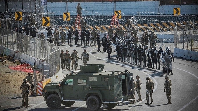 US military personnel and Border Patrol agents gather at the US-Mexico border on Sunday at the San Ysidro border crossing point south of San Diego. (Photo: Getty)