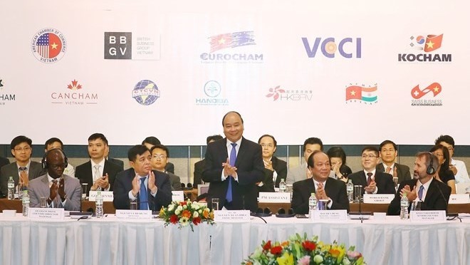 Prime Minister Nguyen Xuan Phuc (standing) addresses the Vietnam Business Forum (Photo VNA)