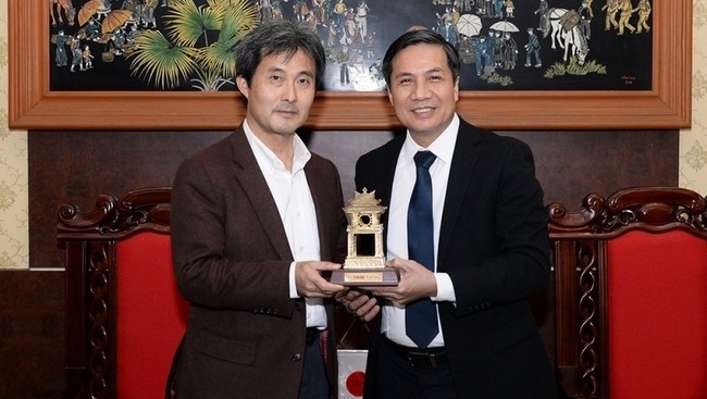 Deputy Editor-in-chief Le Quoc Khanh presents souvenir to Asahi Corporation's representative, Naoto Obama. (Photo: NDO/Thuy Nguyen)