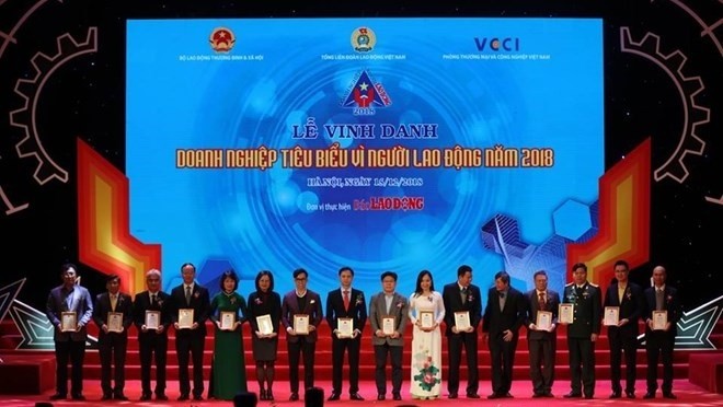 Sixty firms which stood out for their material and spiritual care for labourers are honoured at a ceremony on December 15. (Photo: laodong.vn)