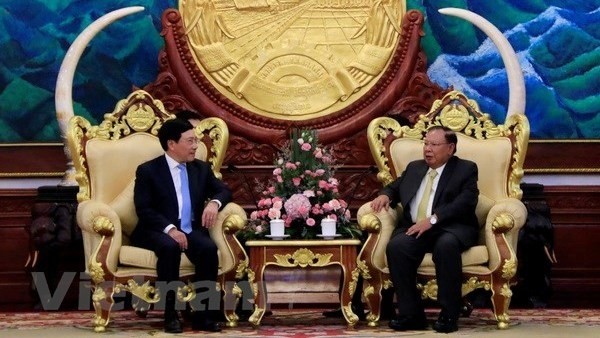 Vietnamese Deputy Prime Minister and Foreign Minister Pham Binh Minh (L) meets with LPRP General Secretary and President Bounnhang Vorachith (Photo: VNA)