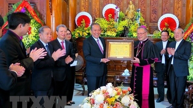 Deputy Prime Minister Truong Hoa Binh (fourth, right) meets with Archbishop Nguyen Chi Linh of the Archdiocese of Hue on December 23 (Photo: VNA)