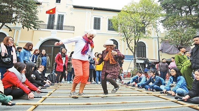 Visitors are joining folk games at the pedestrian street around Hoan Kiem Lake. (Photo: Nhan Dan)