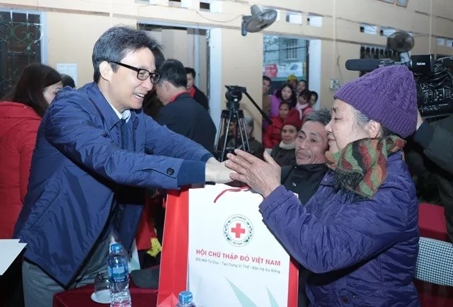 Deputy PM Vu Duc Dam presents gifts to people in Xuat Hoa ward. 