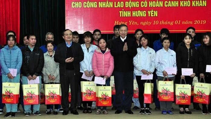Minister of Public Security To Lam (seventh from left)  presents Tet gifts to poor workers in Van Giang district, Hung Yen province (Photo: anninhthudo.vn)