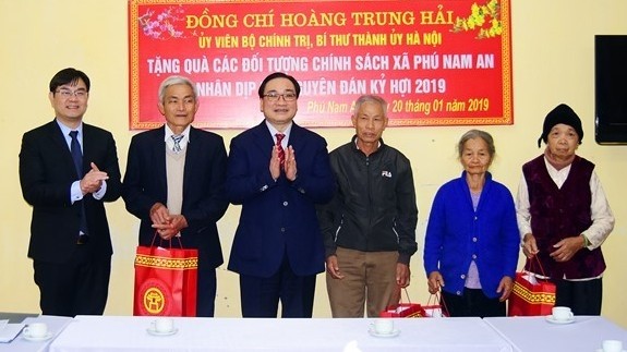 Hanoi Party Committee Secretary Hoang Trung Hai presents Tet gifts to needy households in Phu Nam An commune. (Photo: NDO/Duy Linh)