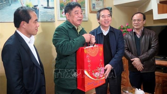 Politburo member  Nguyen Van Binh (third from left) visits  war invalid Nguyen Van Thong in Tan Quang ward, Tuyen Quang city (Photo: VNA)