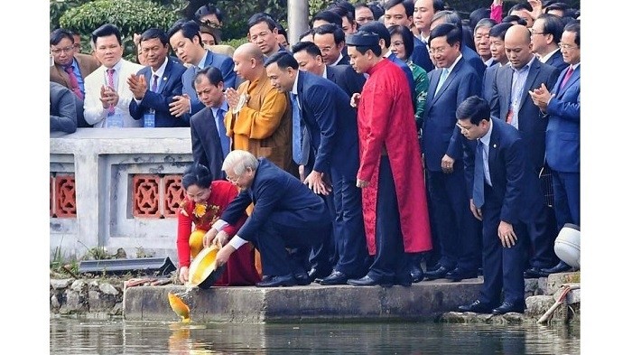 Party General Secretary and State President Nguyen Phu Trong and his spouse release carps into Hanoi’s Hoan Kiem Lake to bid farewell to the Kitchen Gods on January 26. (Photo: zing.vn)